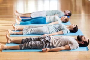 yoga group in corpse pose